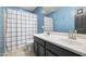 Bathroom with dark vanity, double sinks, and a checkered shower curtain at 4512 W Stoneman Dr, Anthem, AZ 85086