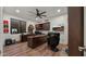 Home office with built-in cabinetry, large desk, and wood flooring at 6429 S Honor Ct, Gilbert, AZ 85298