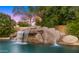 Relaxing pool area with a waterfall and waterslide feature at 6429 S Honor Ct, Gilbert, AZ 85298
