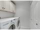 Bright laundry room with washer, dryer, and built-in cabinets at 4645 N 65Th St, Scottsdale, AZ 85251
