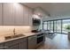 Modern kitchen with stainless steel appliances and living room view at 4808 N 24Th St # 306, Phoenix, AZ 85016