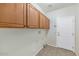 Laundry room with wooden cabinets and exterior access at 19926 N Organ Pipe Dr, Surprise, AZ 85374
