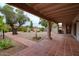 Spacious backyard patio with terracotta tile flooring, lush landscaping, and a covered area at 8307 E Vista De Valle --, Scottsdale, AZ 85255