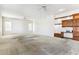 Spacious living room with neutral carpeting, ceiling fan, and built-in shelving at 19435 N 62Nd Ave, Glendale, AZ 85308