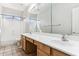 Bathroom with double sinks, wood cabinets, and a large mirror at 19435 N 62Nd Ave, Glendale, AZ 85308
