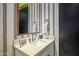 Simple half bathroom with patterned wallpaper and modern fixtures at 37200 N Cave Creek Rd # 1126, Scottsdale, AZ 85262