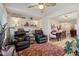 Spacious living room with leather armchairs and a dining area at 10317 W Prairie Hills Cir, Sun City, AZ 85351