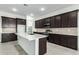 Modern kitchen with dark cabinets, white island, and stainless steel appliances at 7366 E White Tail Rd, San Tan Valley, AZ 85143