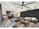 Open-concept living area with a ceiling fan, large TV, and comfortable seating at 20428 W Elm Dr, Buckeye, AZ 85396