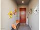 Inviting entryway with a red door, bench, and sunflower wall art at 20428 W Elm Dr, Buckeye, AZ 85396