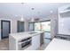 Modern kitchen with a large island, stainless steel appliances, and sliding glass doors to backyard at 7544 E Mckinley St, Scottsdale, AZ 85257
