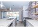 Modern kitchen with stainless steel appliances and a view to the backyard pool at 7544 E Mckinley St, Scottsdale, AZ 85257