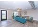 Modern living room with teal sofa and wood-look floors at 7544 E Mckinley St, Scottsdale, AZ 85257
