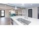 Modern kitchen island with stainless steel sink and faucet, overlooking living room at 7544 E Mckinley St, Scottsdale, AZ 85257