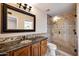 Bathroom with granite countertop, wood cabinets and a glass shower at 591 E Park Ave, Gilbert, AZ 85234