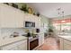 Bright kitchen features white cabinets, tile backsplash, and stainless steel appliances at 17800 W Primrose Ln, Surprise, AZ 85374