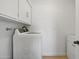 Laundry room with washer and dryer, white cabinets, and wood floor at 1455 E Tuckey Ln, Phoenix, AZ 85014