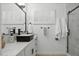 Modern bathroom with black vanity, marble shower, and white walls at 1455 E Tuckey Ln, Phoenix, AZ 85014