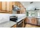 Modern kitchen with wood cabinets, stainless steel appliances, and granite countertops at 20026 N 106Th Ave, Sun City, AZ 85373