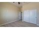 Bright bedroom with ceiling fan, tile flooring, and double doors to closet at 2303 S 337Th Ave, Tonopah, AZ 85354