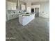 Spacious kitchen featuring white cabinets, marble island, and grey wood-look tile floors at 2303 S 337Th Ave, Tonopah, AZ 85354
