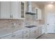 Modern kitchen with white cabinets, stainless steel appliances, and stone backsplash at 2303 S 337Th Ave, Tonopah, AZ 85354