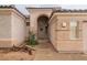 Home entrance with arched entryway, a wreath on the door, and landscaping at 7951 E Posada Ave, Mesa, AZ 85212