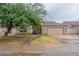 Tan one-story house with a tile roof, two-car garage, and a tree in front at 7951 E Posada Ave, Mesa, AZ 85212
