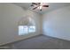 Bright bedroom with arched window and ceiling fan at 7951 E Posada Ave, Mesa, AZ 85212