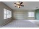 Living room with patterned wall, neutral walls, and a ceiling fan at 7951 E Posada Ave, Mesa, AZ 85212