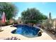 Freeform swimming pool with a waterfall feature and patio at 4321 E Desert Sky Ct, Cave Creek, AZ 85331