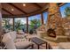 Stone fireplace with seating area in a covered patio, overlooking the desert at 40523 N 102Nd Pl, Scottsdale, AZ 85262