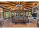 Spacious living room with a circular wooden ceiling, stone floor, and large windows at 40523 N 102Nd Pl, Scottsdale, AZ 85262