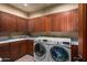 Laundry room with wooden cabinets and washer/dryer at 40523 N 102Nd Pl, Scottsdale, AZ 85262