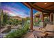 Relaxing patio area with a fireplace and comfortable seating, overlooking the desert landscape at 40523 N 102Nd Pl, Scottsdale, AZ 85262