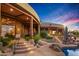 Luxury home's backyard featuring a pool and stone patio at sunset at 40523 N 102Nd Pl, Scottsdale, AZ 85262