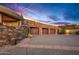 Four-car garage with stone facade and sunset view at 40523 N 102Nd Pl, Scottsdale, AZ 85262