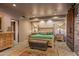 Main bedroom with a large bed, wooden furniture, and a rustic brick accent wall at 40523 N 102Nd Pl, Scottsdale, AZ 85262