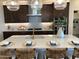 Modern kitchen with dark cabinetry, quartz countertops, and a large island at 9963 W Cora Ln, Avondale, AZ 85392