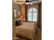 Guest bedroom with a comfortable bed and arched window with shutters at 9963 W Cora Ln, Avondale, AZ 85392