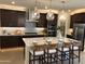 Spacious kitchen featuring dark wood cabinets and a large island with seating at 9963 W Cora Ln, Avondale, AZ 85392