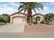 Single story home with a two car garage and palm tree at 17828 W Mariposa Dr, Surprise, AZ 85374