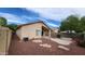 Back of house with covered patio, gravel landscaping and block wall at 3347 W Steinbeck Dr, Anthem, AZ 85086