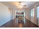 Bright dining room features dark hardwood floors and a view into the kitchen at 17186 W Post Dr, Surprise, AZ 85388
