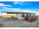 Mobile home with carport, deck, and desert landscaping at 52320 W Foothill Trl, Maricopa, AZ 85139