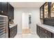 Butler's pantry with wine cooler, custom cabinetry, and granite countertops at 8014 E Del Tesoro Dr, Scottsdale, AZ 85258