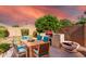 Outdoor dining area with a wooden table and blue chairs near a built-in grill at 2754 W Tanner Ranch Rd, San Tan Valley, AZ 85144