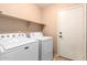 Bright laundry room, featuring a washer and dryer and overhead shelving at 2754 W Tanner Ranch Rd, San Tan Valley, AZ 85144