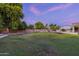 Landscaped backyard at twilight, featuring a large lawn and lighting at 1912 E Gemini Pl, Chandler, AZ 85249