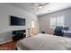 Bright bedroom featuring a large TV, built-in desk, and wood floors at 1912 E Gemini Pl, Chandler, AZ 85249